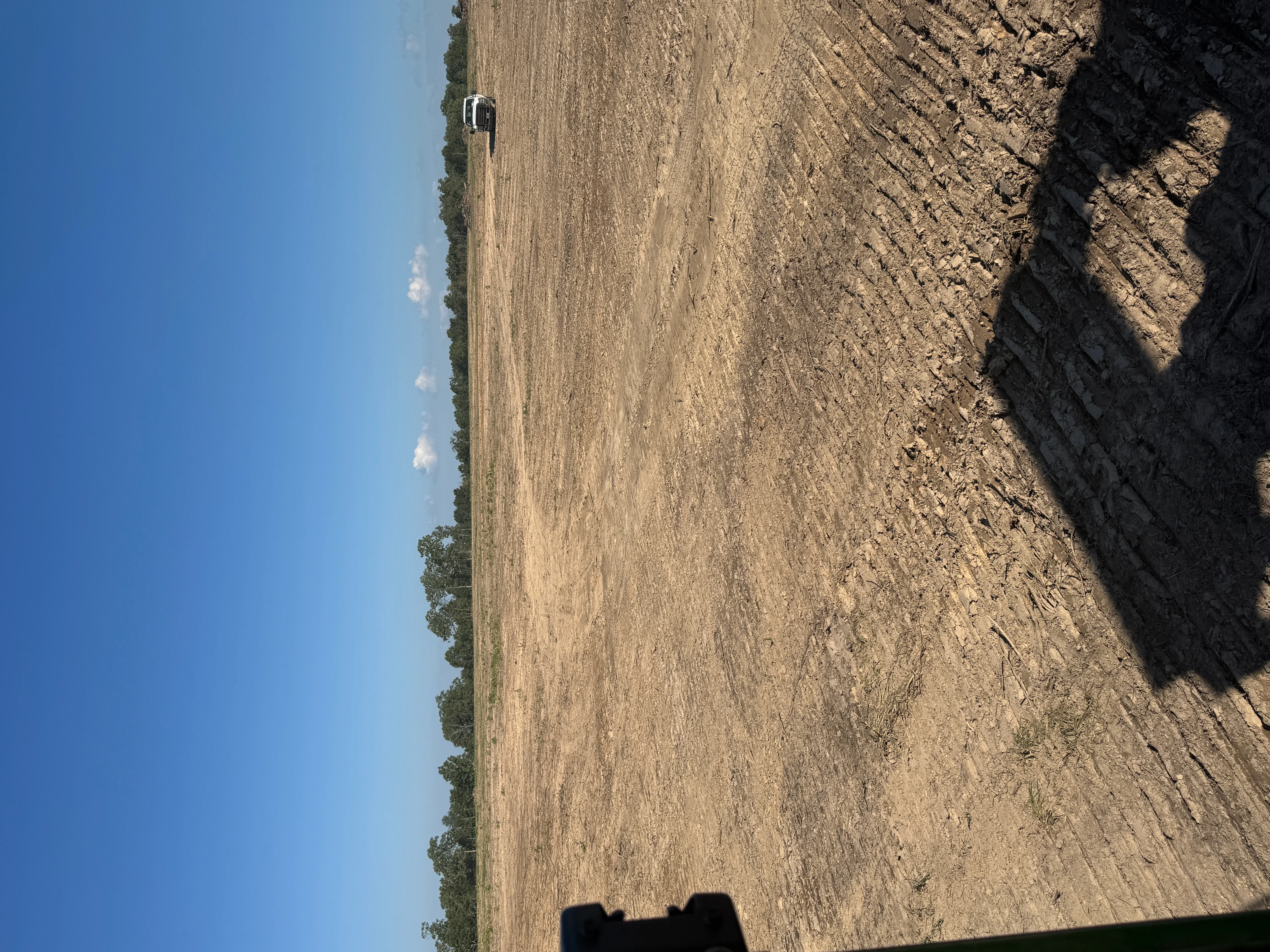 Cleared and graded dirt lot with equipment, showing land preparation and site clearing work